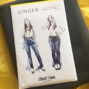 A copy of the Ginger Jeans sewing pattern on top of some denim fabric