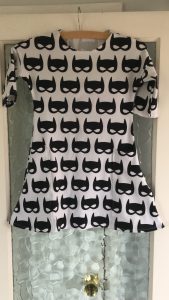 A white girls dress with Batman masks printed on it