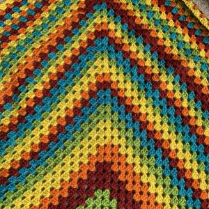A rainbow crocheted granny square blanket
