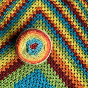 A crocheted rainbow granny square blanket