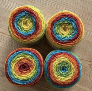 four large balls of yarn in rainbow colours