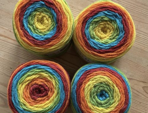 four large balls of yarn in rainbow colours