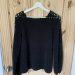 Rosie's latest make: granny go round jumper. A black crochet jumper having on the back of a wooden door.